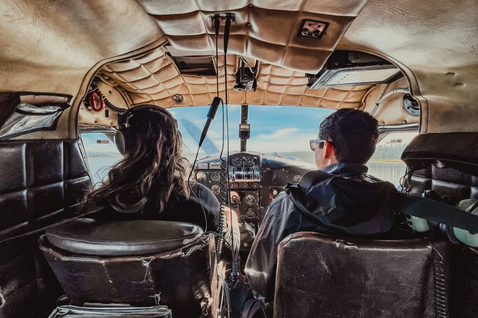 Passengers looking through the cockpit of a small plane