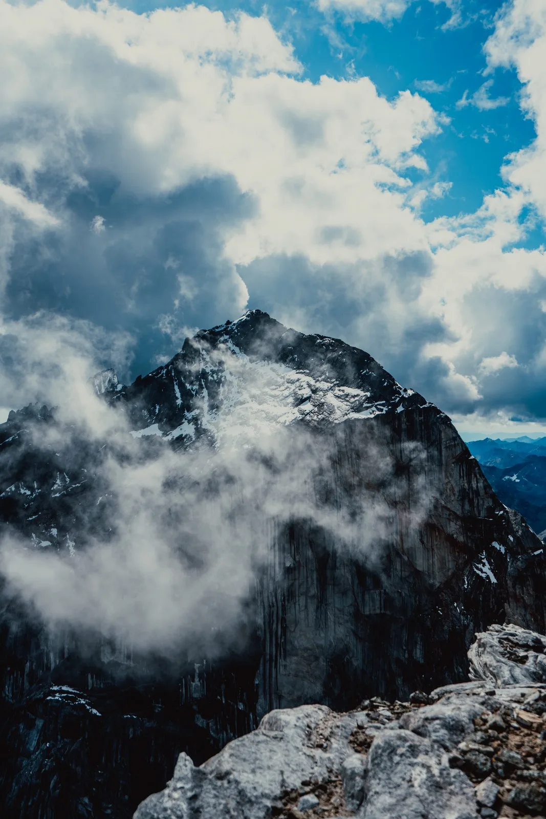 A dark mountain summit breaking through low cloud
