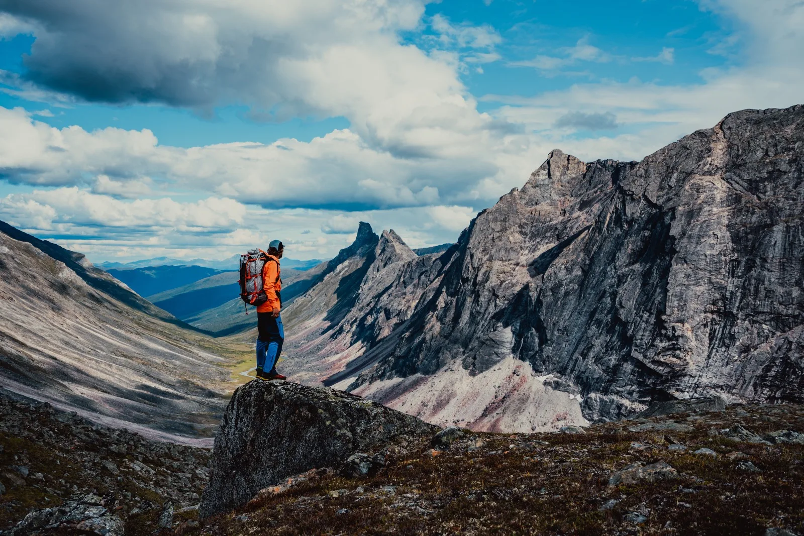 A backpacker pausing on a high rocky ridge