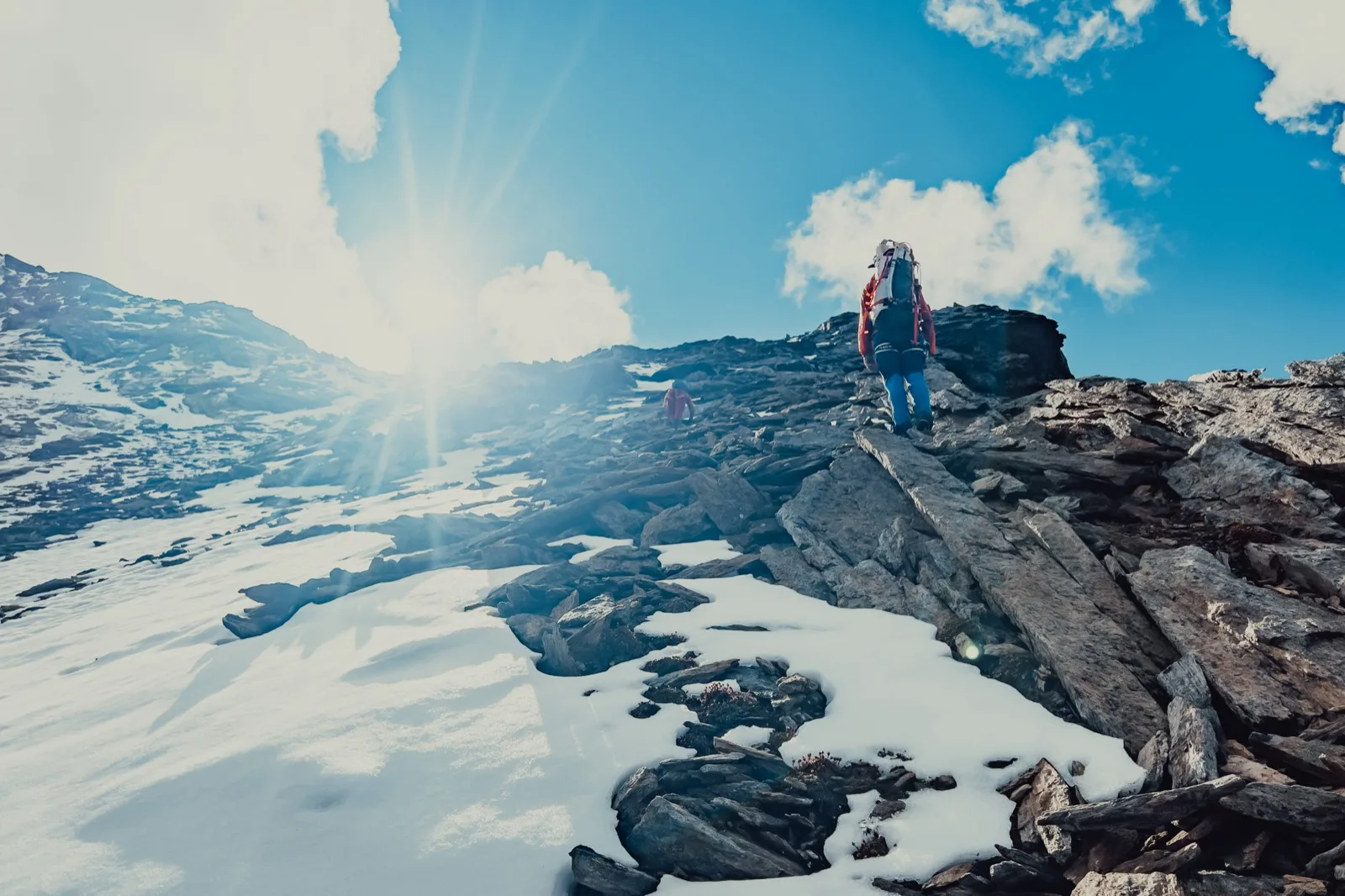 A climber moving through sunlit mountain rock