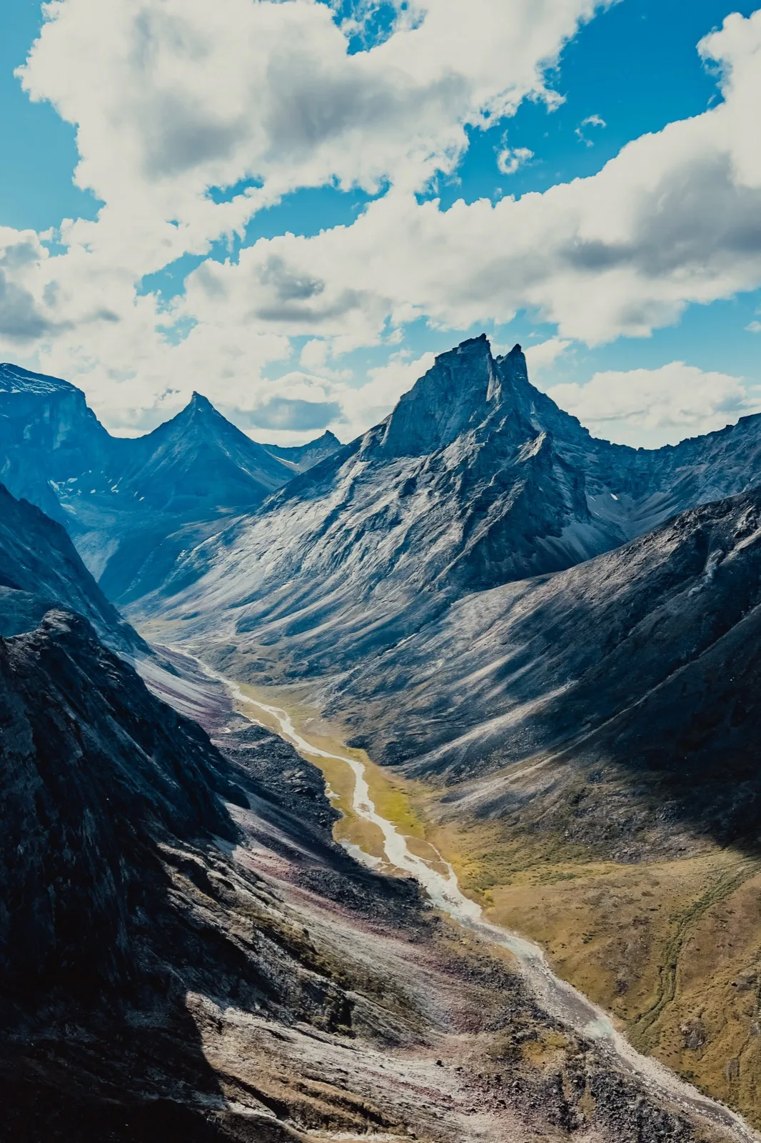A lone figure looking across a vast green valley