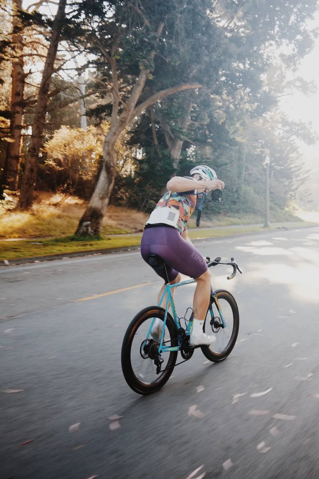 A cyclist riding into warm backlight on an open road