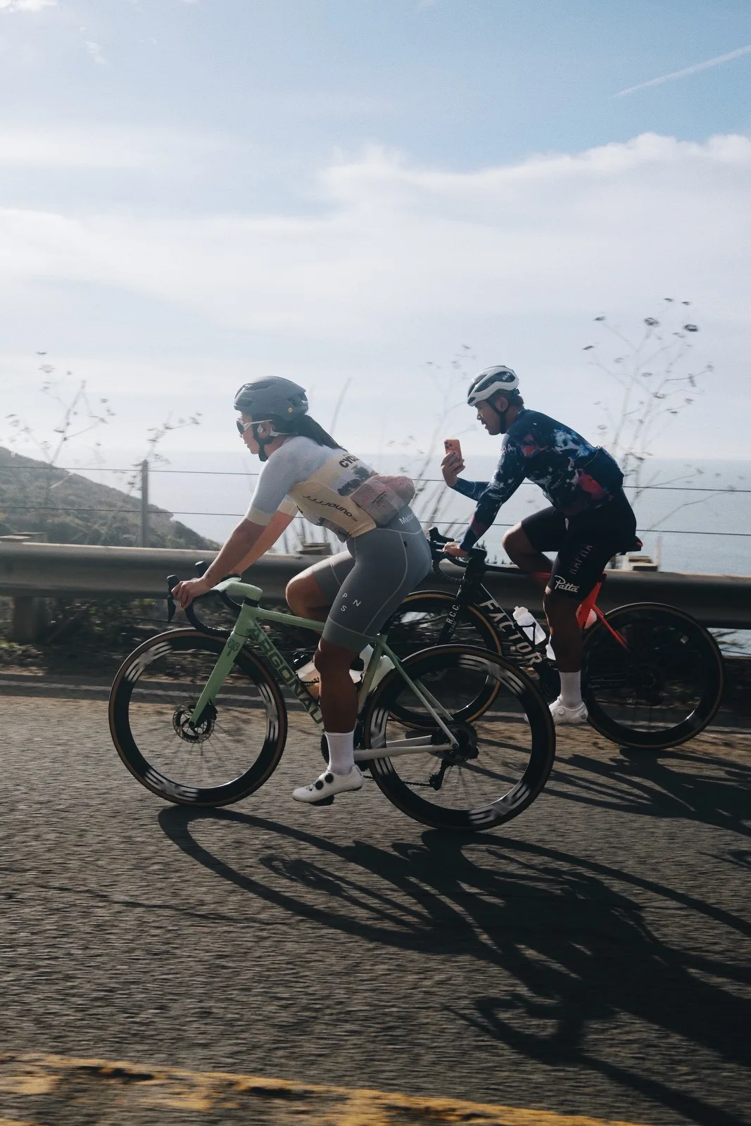Two cyclists riding beneath the Golden Gate Bridge
