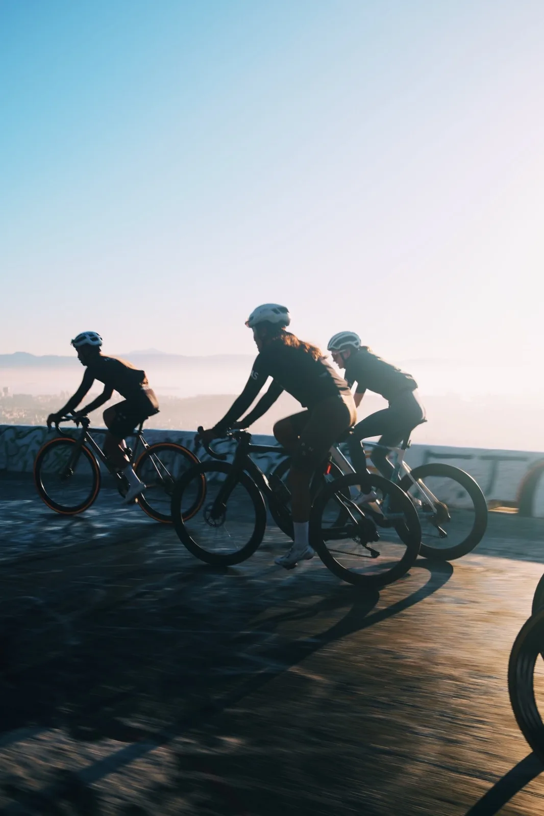 A group ride silhouetted against a pale horizon