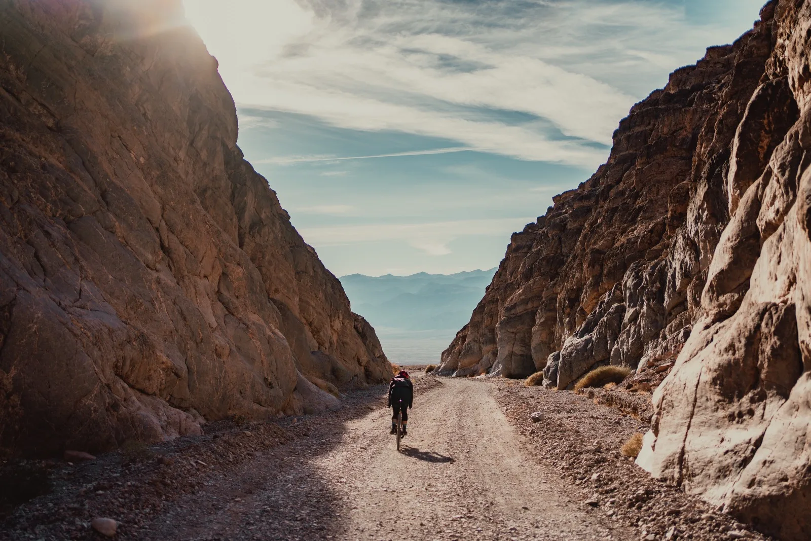 A hiker walking alone through a high canyon