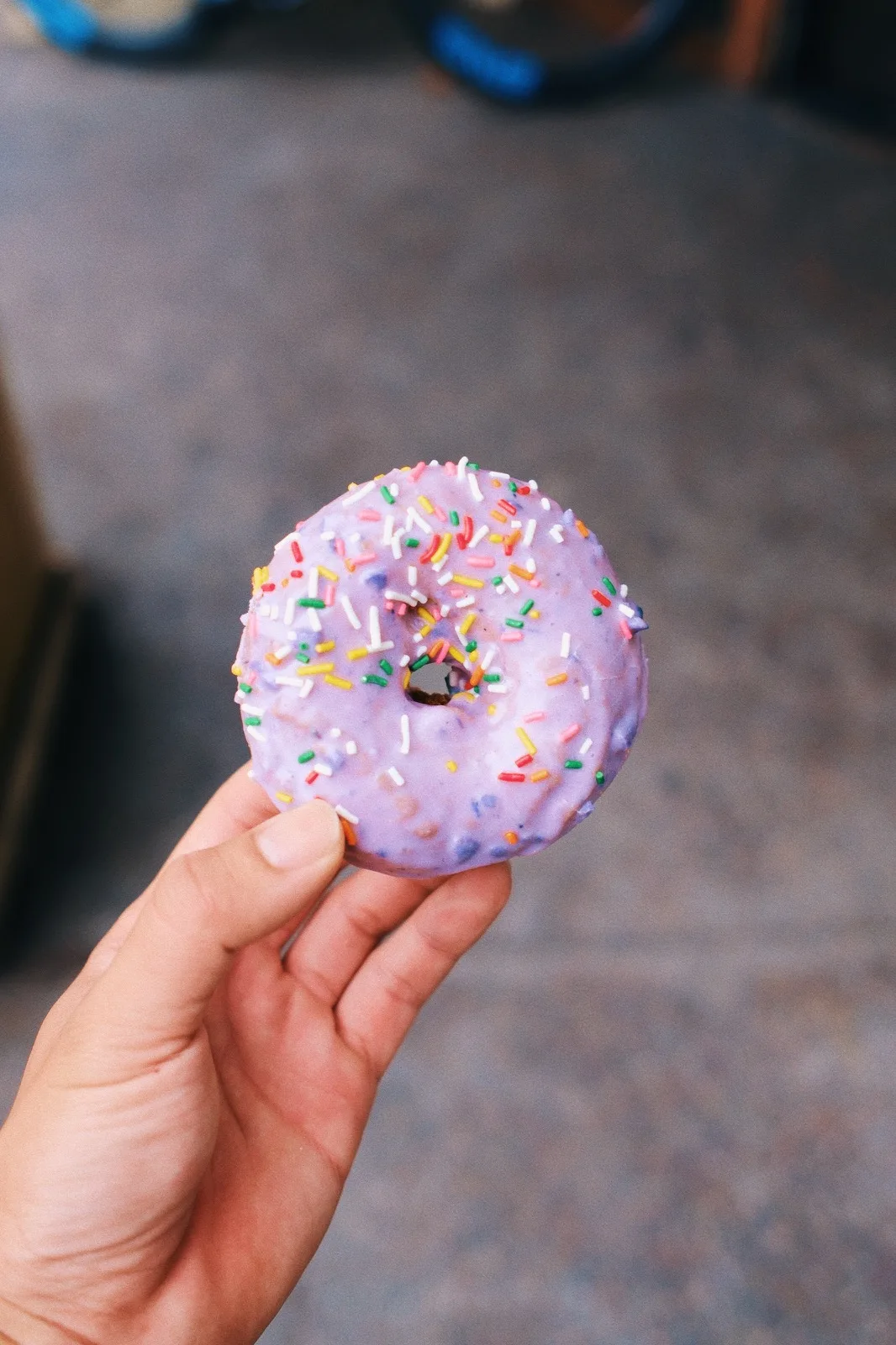A sprinkle-covered doughnut held up to the camera
