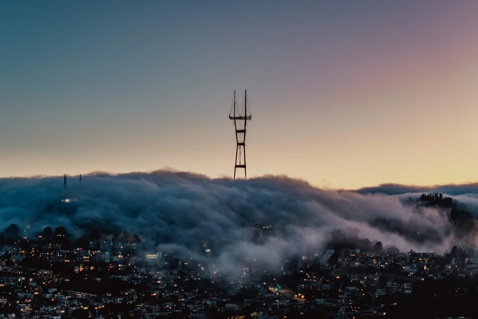 Sutro Tower rising above a river of fog at sunset