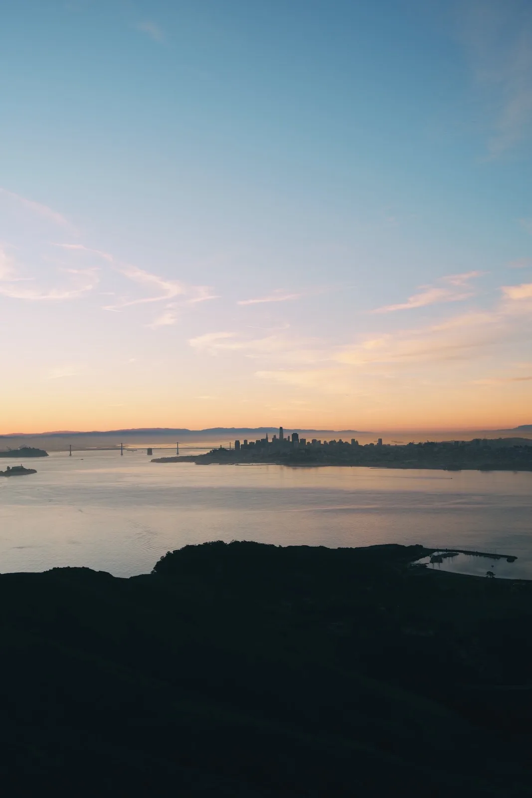 A tiny island and distant hills beneath layers of fog