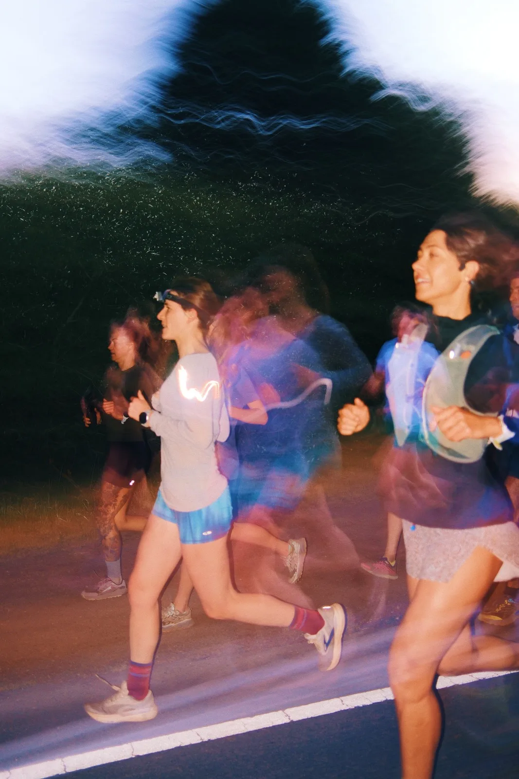 Runners dissolving into layered blue and violet motion
