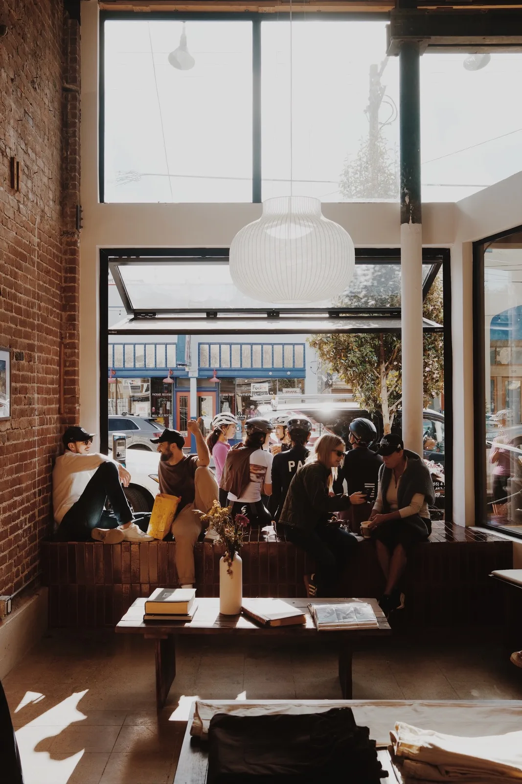 Friends gathered in the window of a sunlit cafe