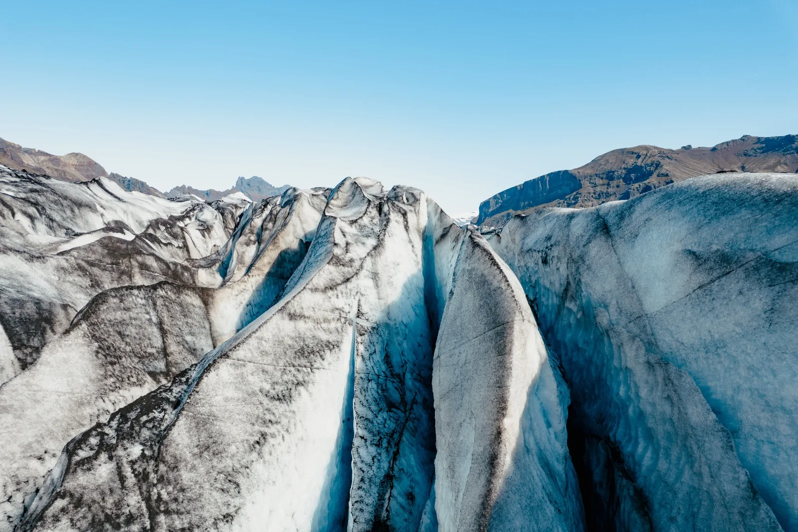 Aerial view of deep blue crevasses in a glacier