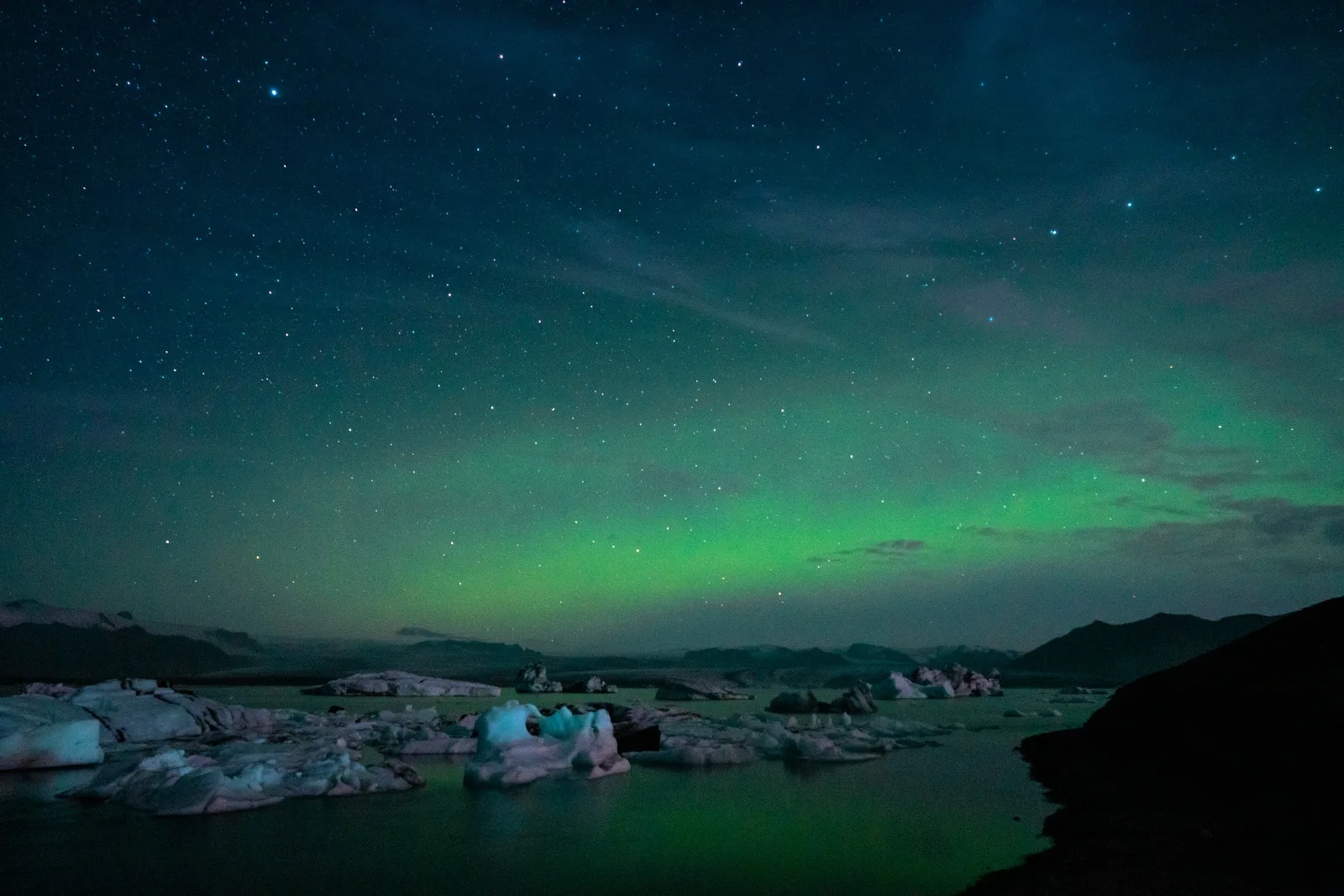 Green northern lights glowing above a small town