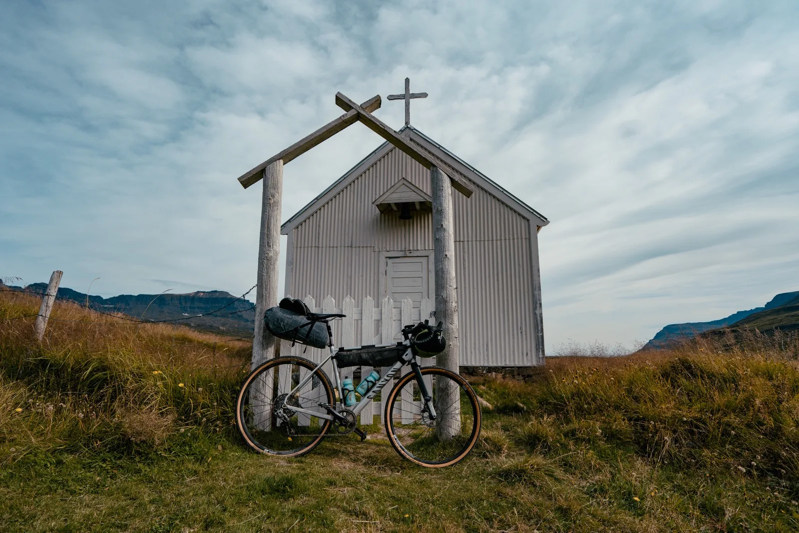 Two bicycles leaning against a tiny white church
