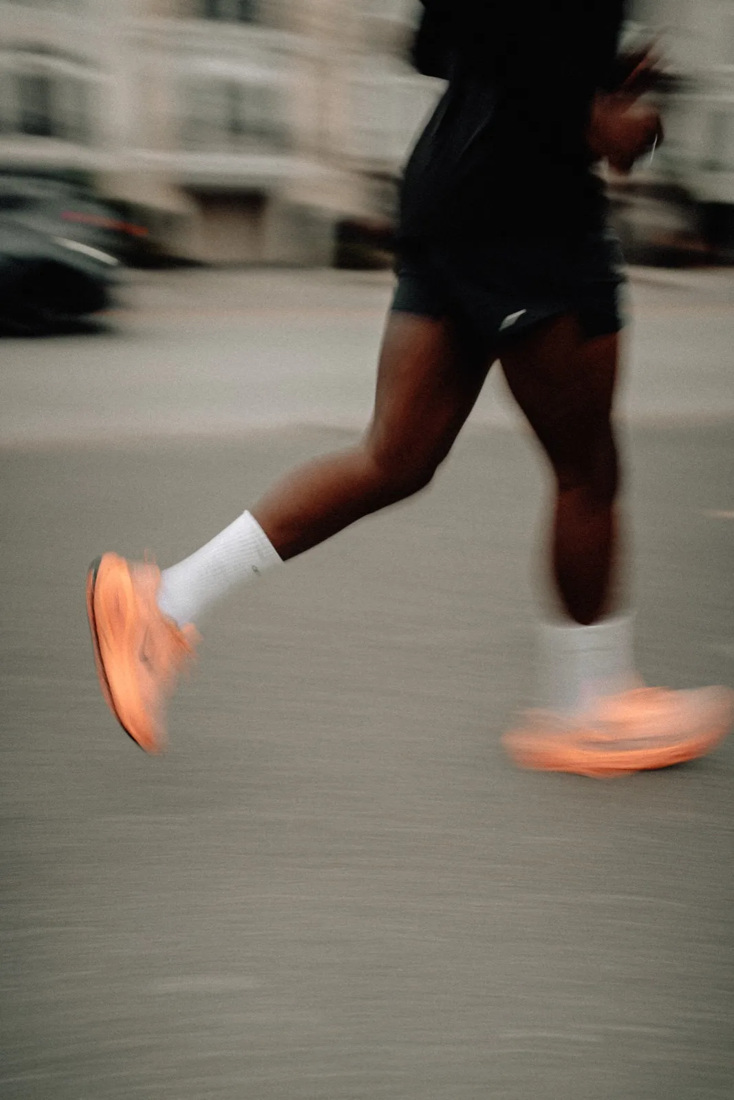 A bright orange shoe blurred in mid-stride