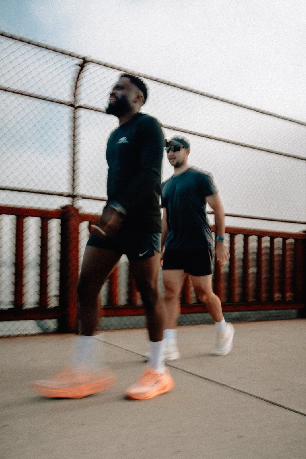 Two runners passing close to the camera on the Golden Gate Bridge