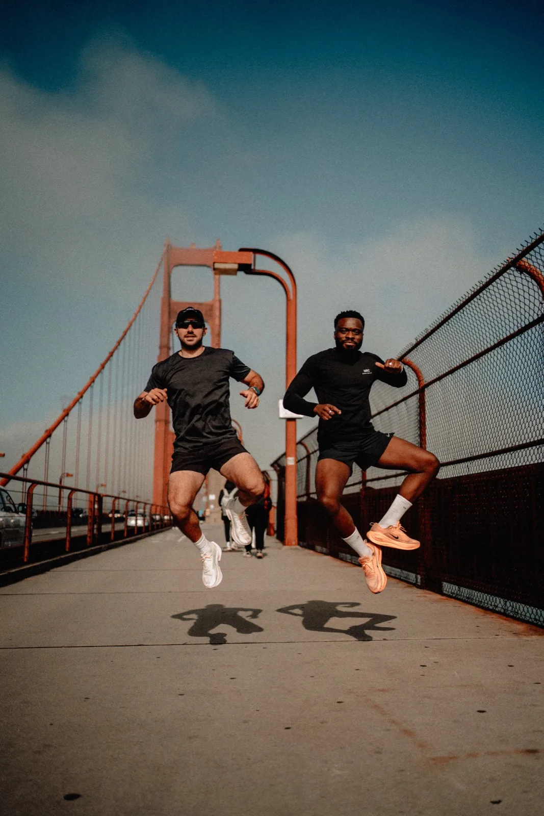 Two MRC runners jumping on the Golden Gate Bridge