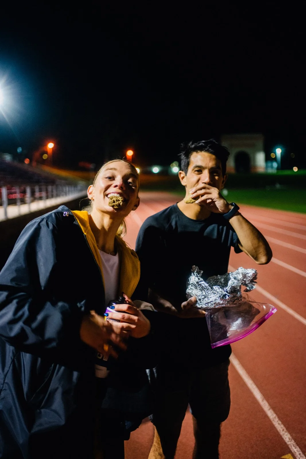 Two runners sharing a snack after track practice