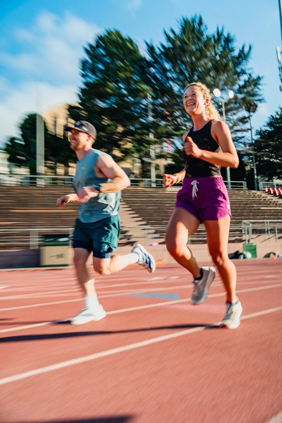 Two runners smiling through a fast track interval