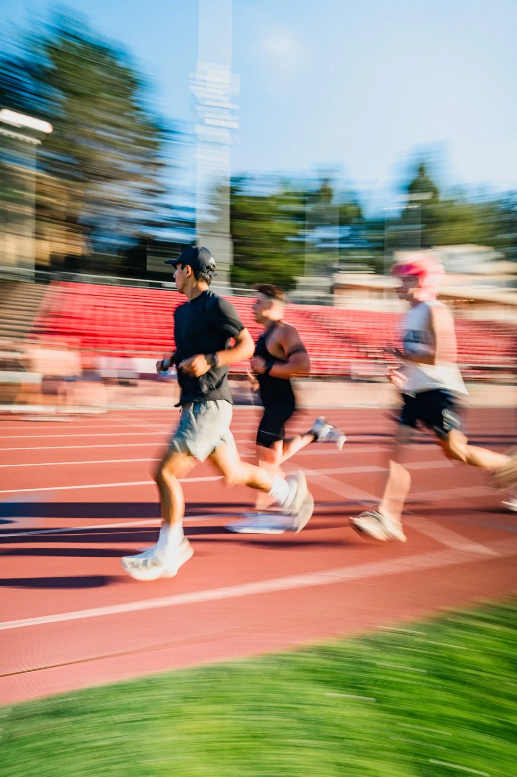 A pack of runners blurred across the red track