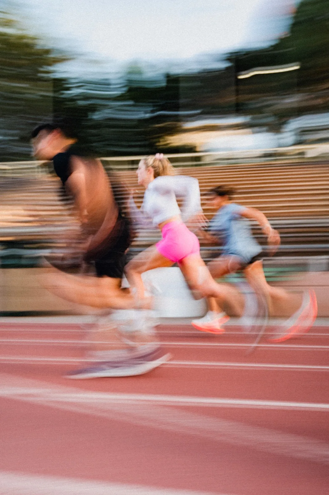 Runners streaking past during an evening track workout