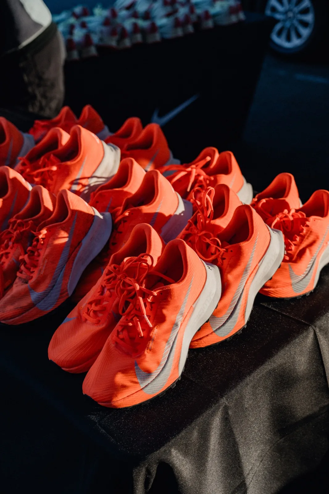 A pile of orange Nike trail shoes