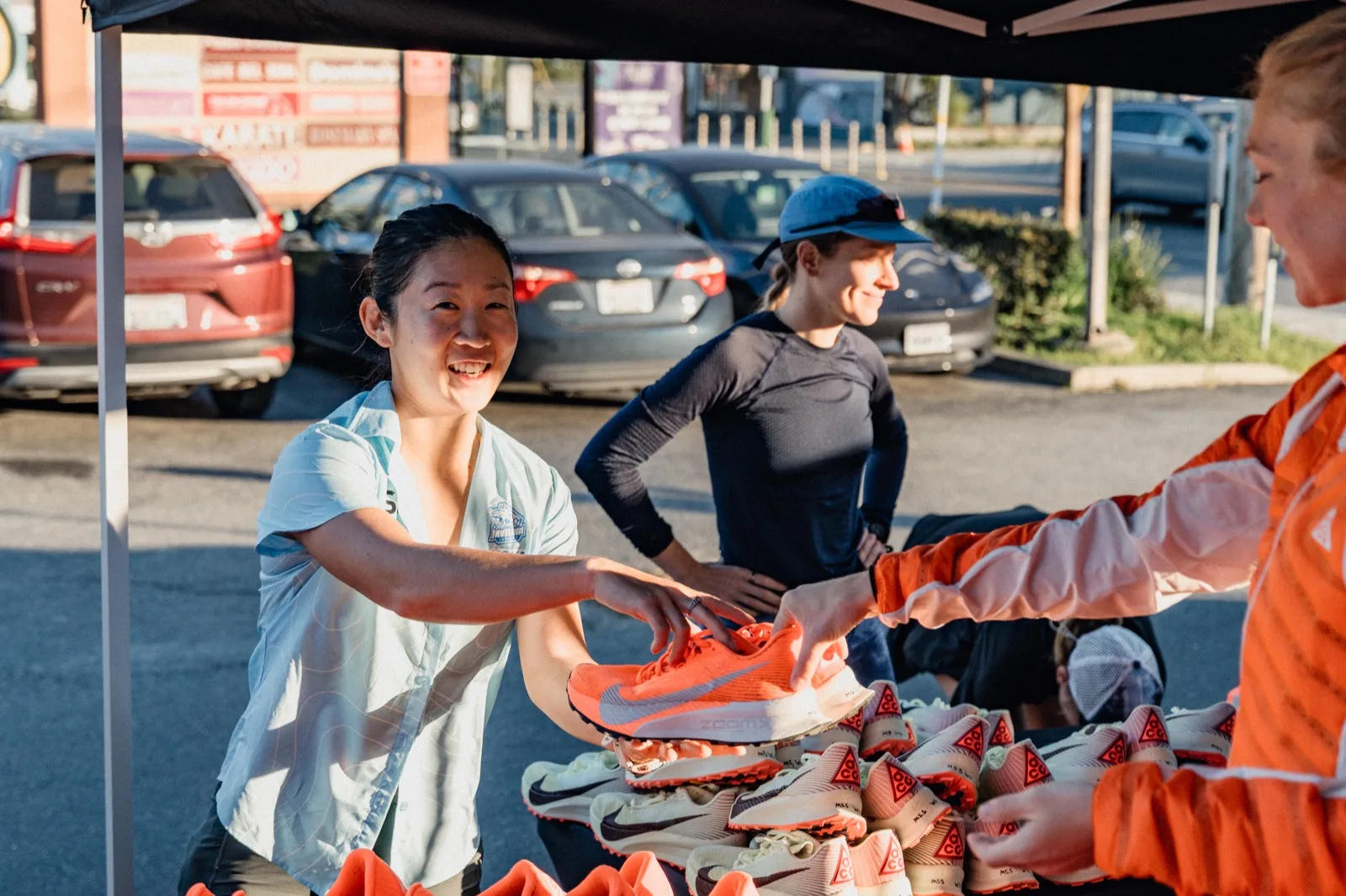 Runners collecting trail shoes beneath a canopy