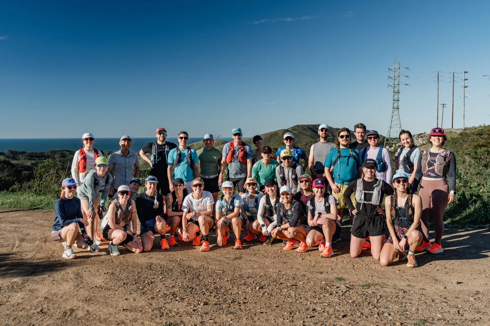 A large trail-running group portrait on a ridge