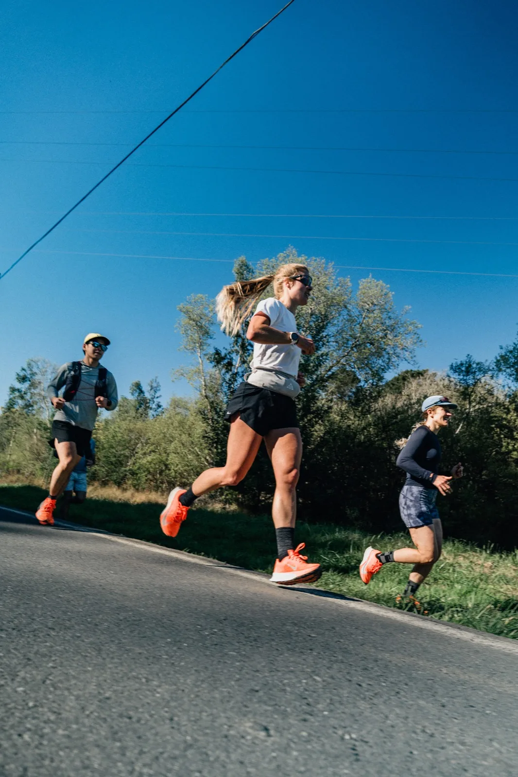 A runner caught mid-stride against a blue sky