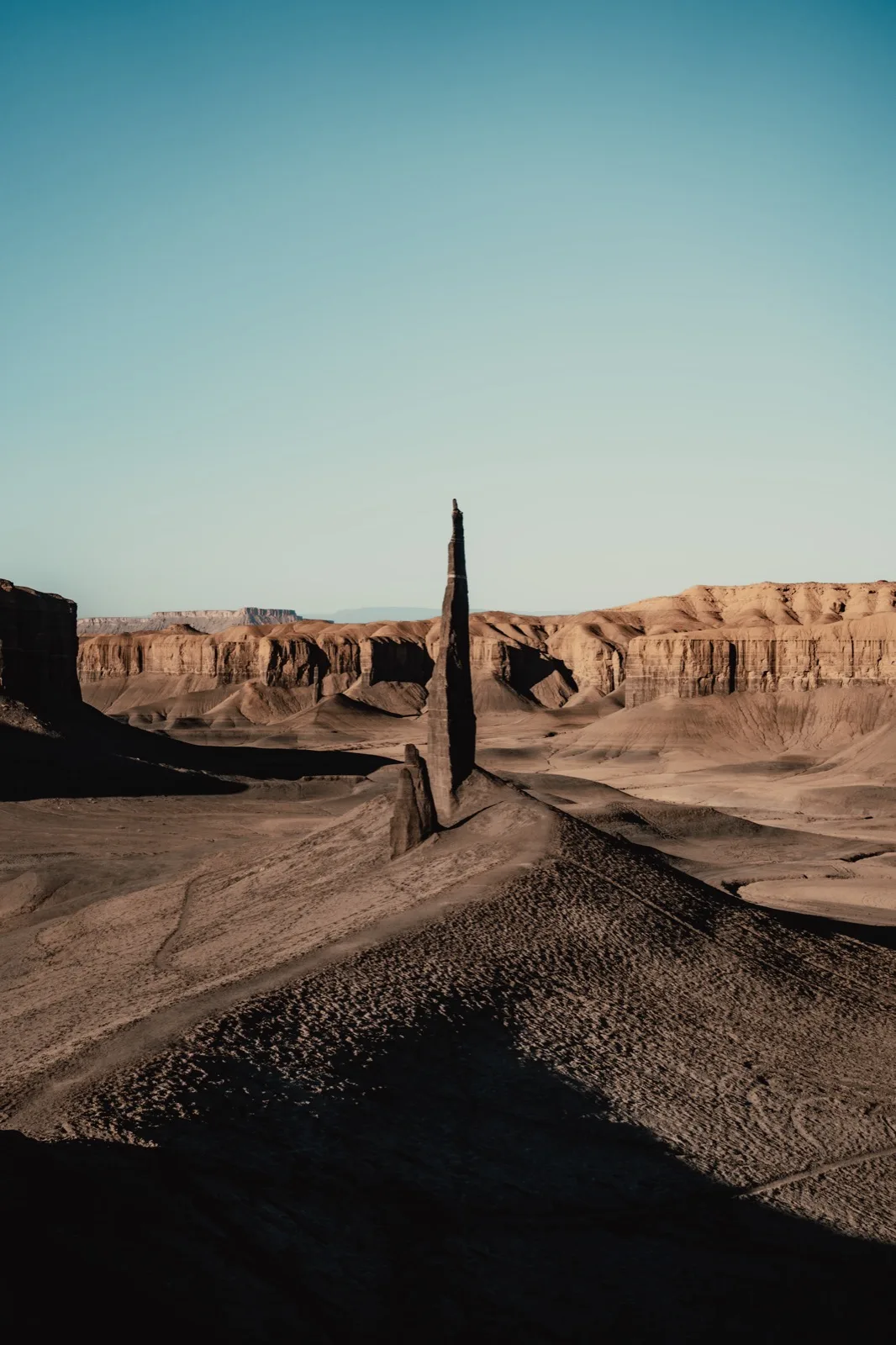A narrow stone fin rising from rippled badlands