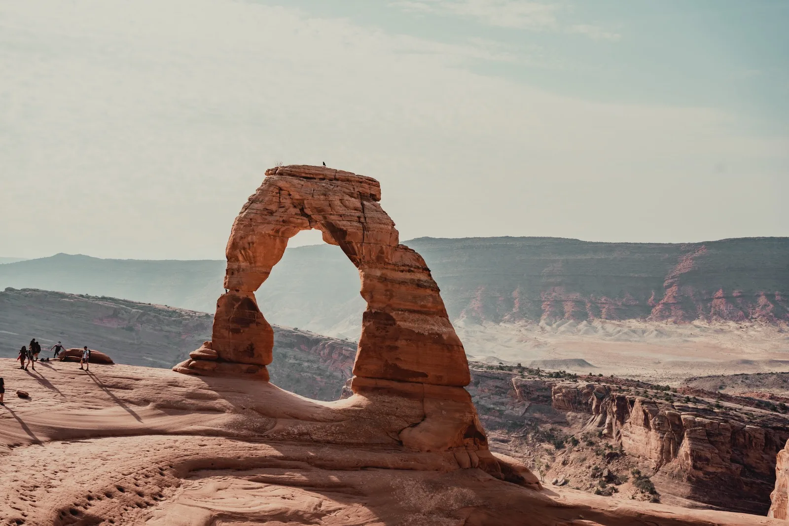 Delicate Arch standing above distant canyons