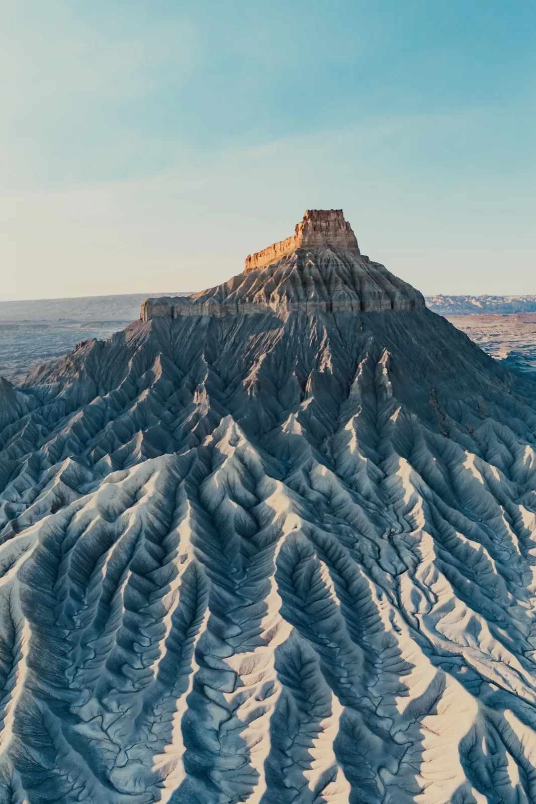 Factory Butte rising from deeply folded desert badlands