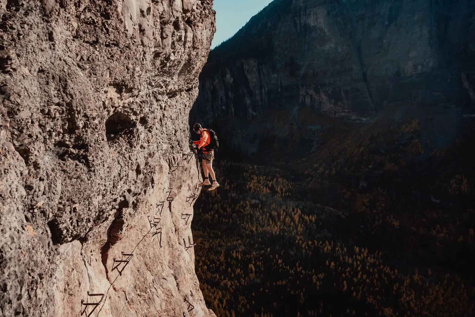 A climber traversing a steep Colorado via ferrata
