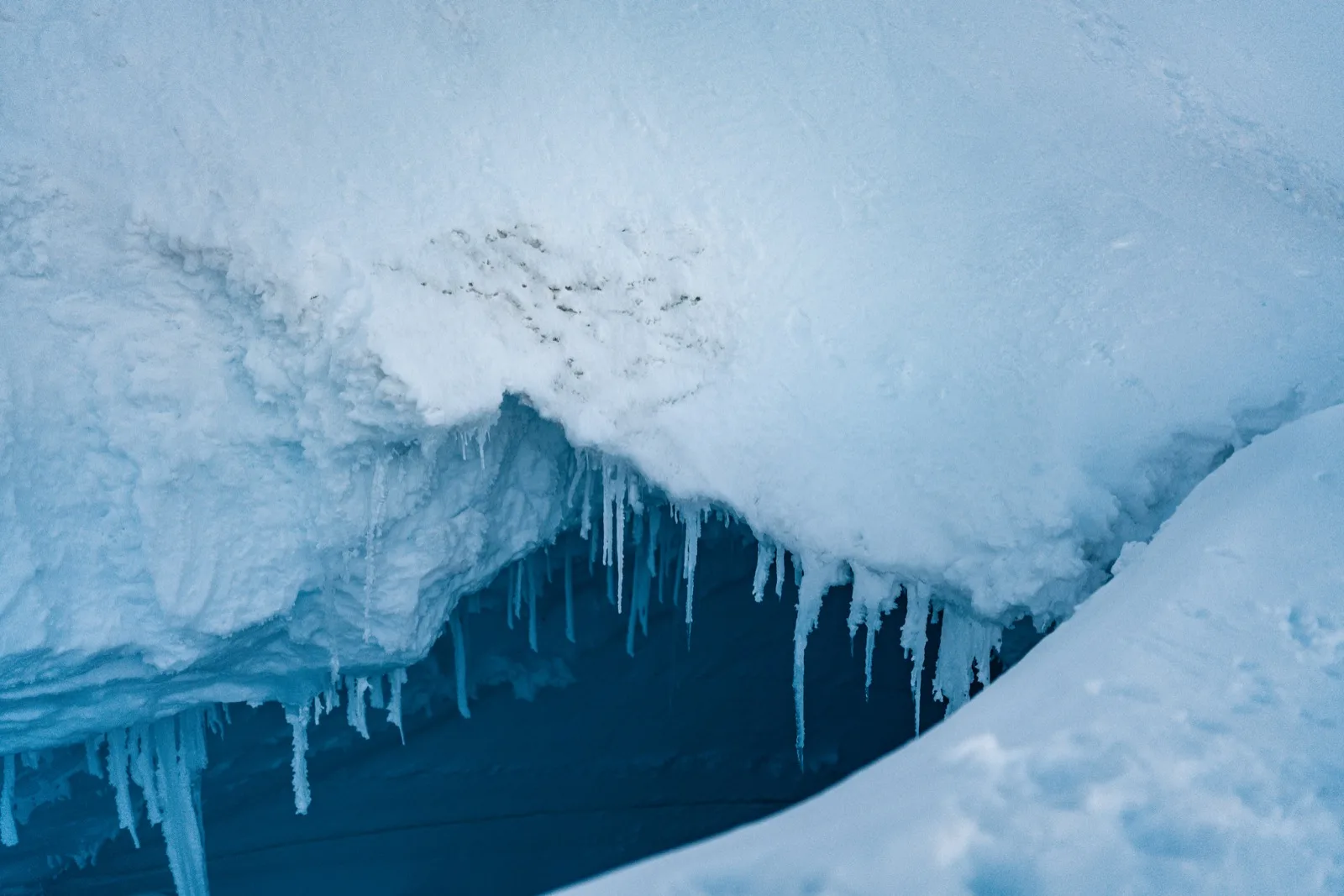 Blue ice and hanging icicles in close detail
