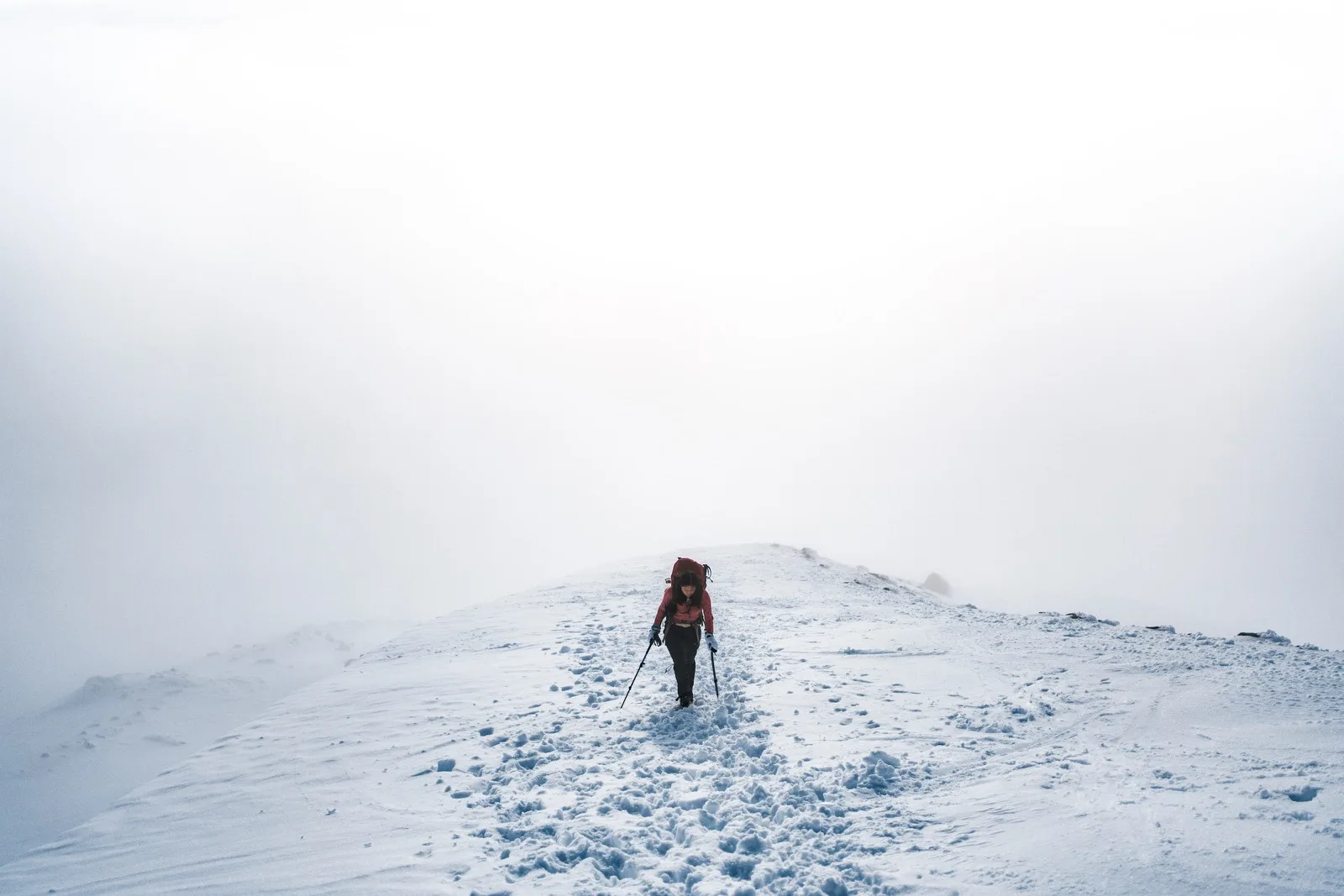 Climbers moving through warm sunlit cloud on a snowy slope